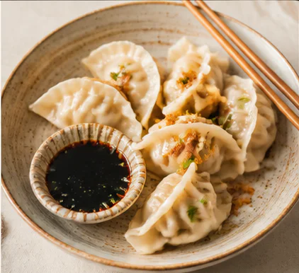 A plate of dumplings with dipping sauce representing Singapore dining discoveries